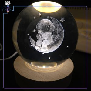 گوی کریستالی قطر 8 سانتی متر طرح فضانورد نشسته بر روی ماه گل در دست پایه چوبی