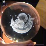 گوی کریستالی قطر 8 سانتی متر طرح فضانورد نشسته بر روی ماه گل در دست پایه چوبی