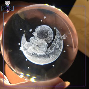 گوی کریستالی قطر 8 سانتی متر طرح فضانورد نشسته بر روی ماه گل در دست پایه چوبی